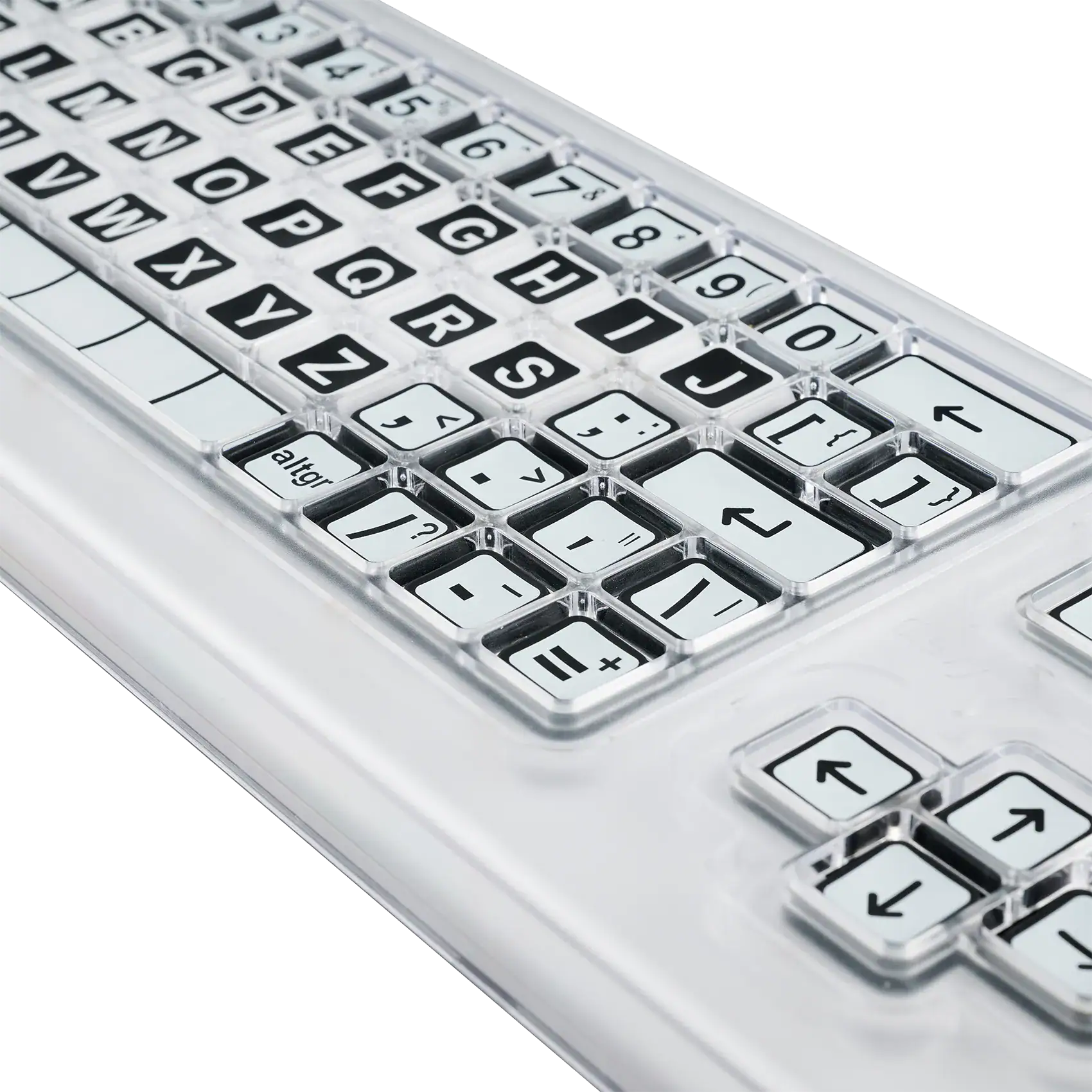 Close up image of a black and white keyboard with a clear perspex keyguard separating the keys.