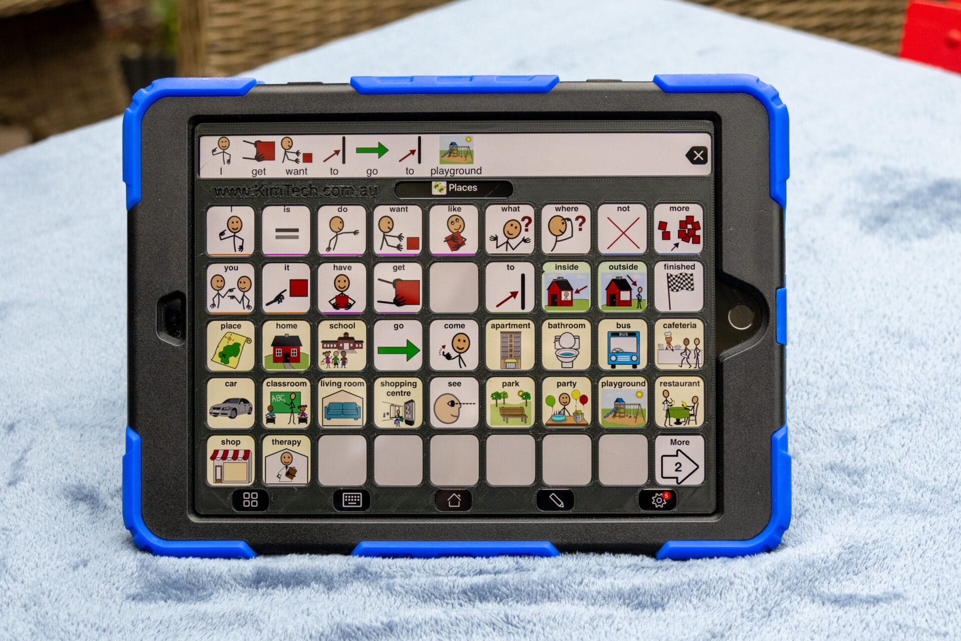 An iPad displaying Proloquo2go 5 by 9 grid layout with a 3D printed keyguard.