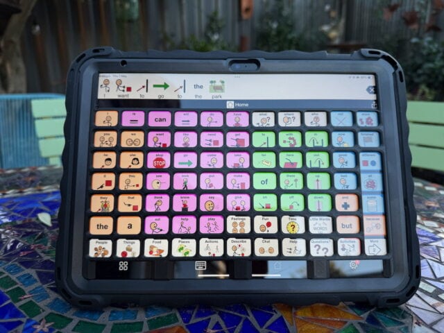 A black keyguard on an iPad with Proloquo2go page set displayed.