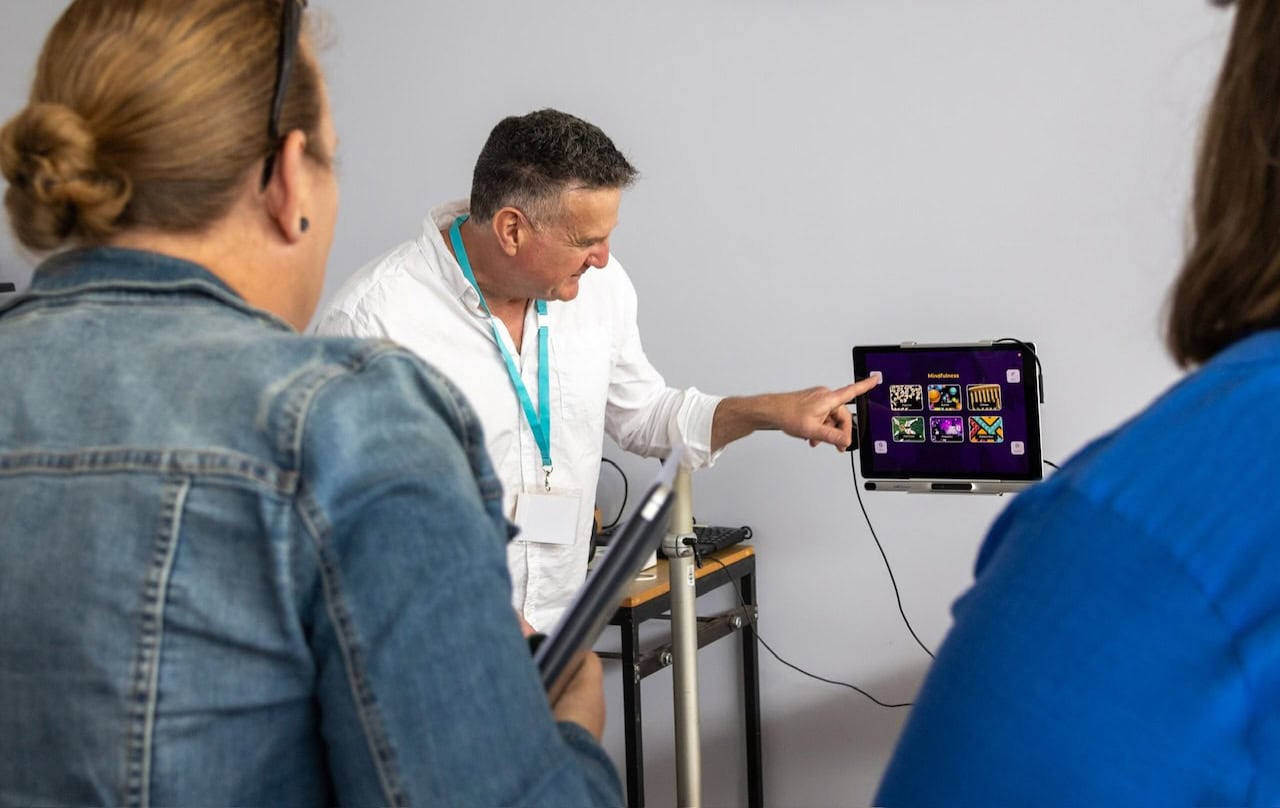 Occupational therapist demonstrating an eye gaze communication device to allied health professionals during an AAC and assistive technology training session, highlighting alternative access methods for people with complex communication needs.