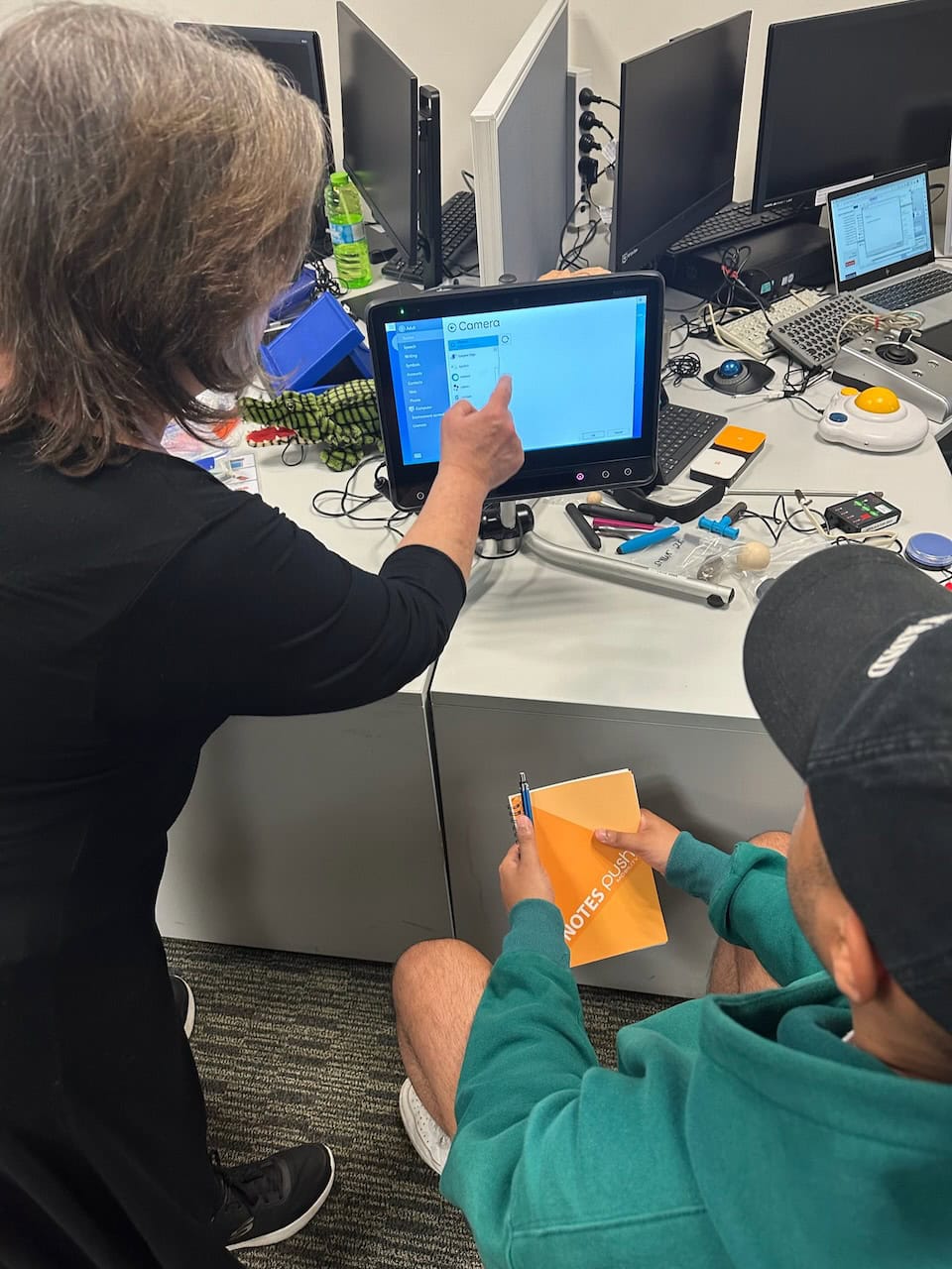 Occupational therapist setting up a Tobii Dynavox eye gaze communication device during an AAC and assistive technology assessment, demonstrating alternative access methods for people with complex communication needs.